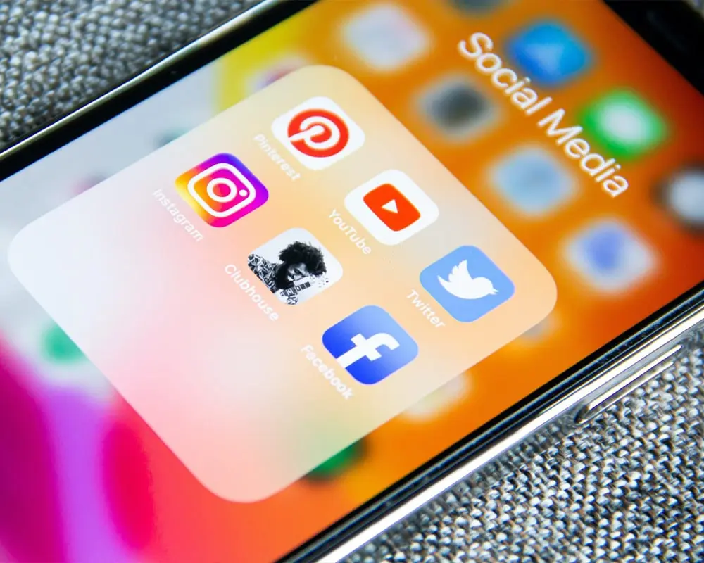 A detailed closeup of an iPhone screen showcasing popular social media app icons in vibrant colors, emphasizing modern connectivity, communication, and the digital era of social interaction.